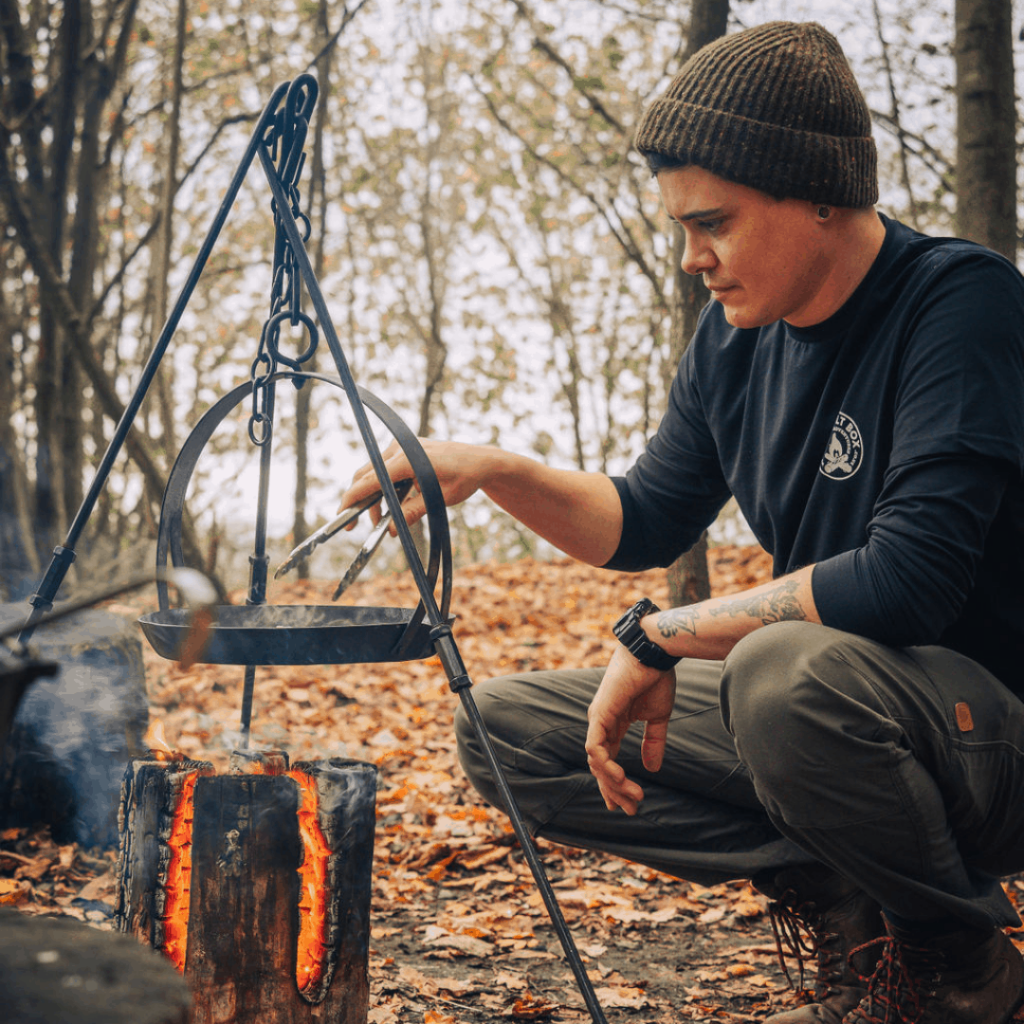 Christian cooking with a dutch oven over fire